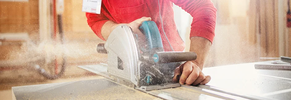 Person sägt Holz mit Handkreissäge